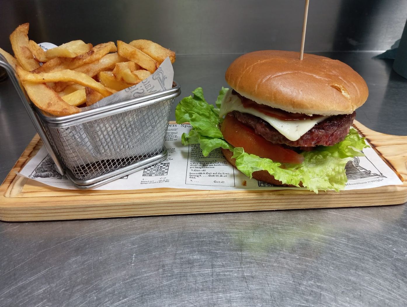 Hamburguesa completa con queso fundido, tomate, lechuga y patatas fritas caseras